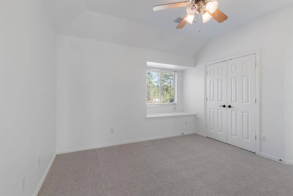 Cozy and bright secondary upstairs bedroom with closet space and a charming window alcove.