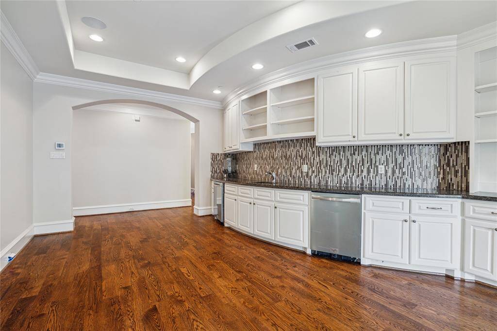 This space features gleaming hardwood floors, custom cabinetry, and two beverage fridges. Perfect for entertaining and everyday living.