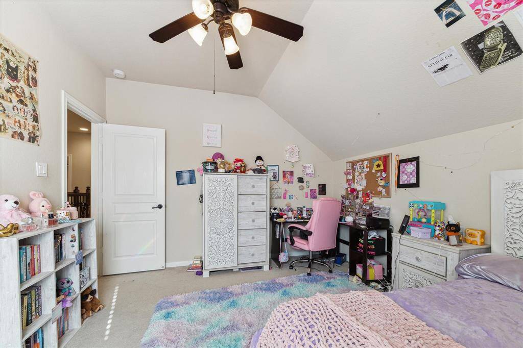 This second floor cozy bedroom features a vaulted ceiling, a ceiling fan, and a neutral color palette.