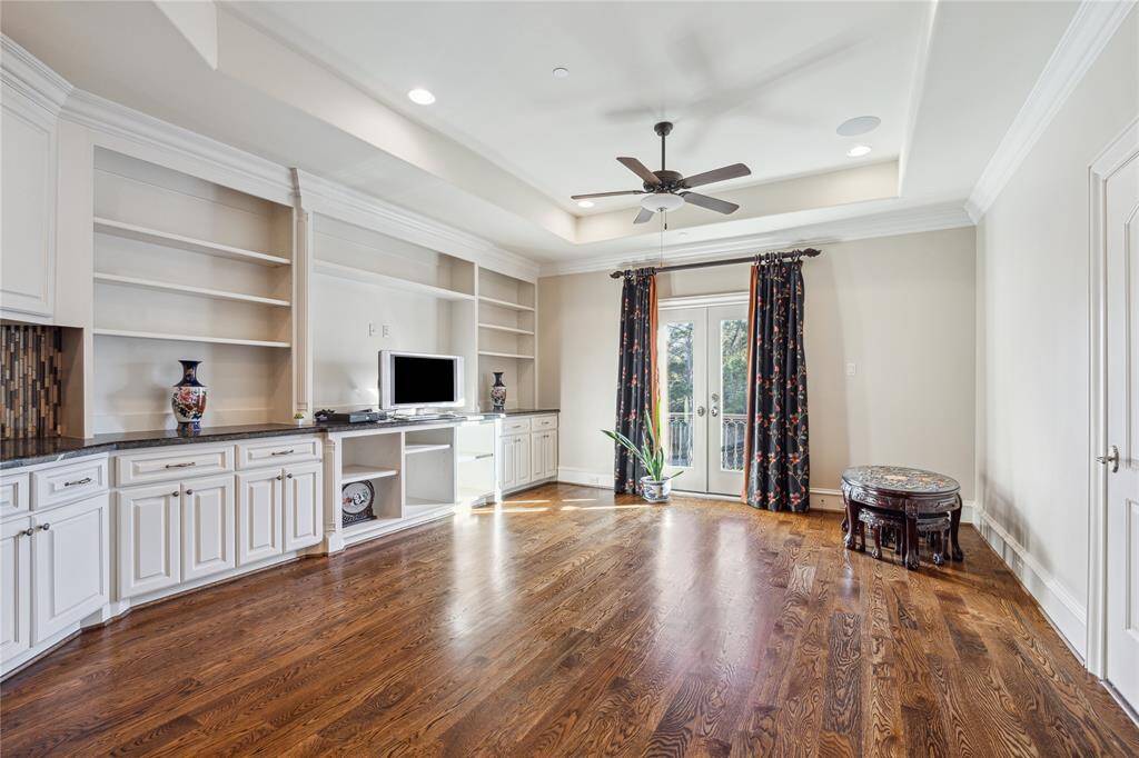 Game room with  built-in shelving, and a stylish entertainment center.