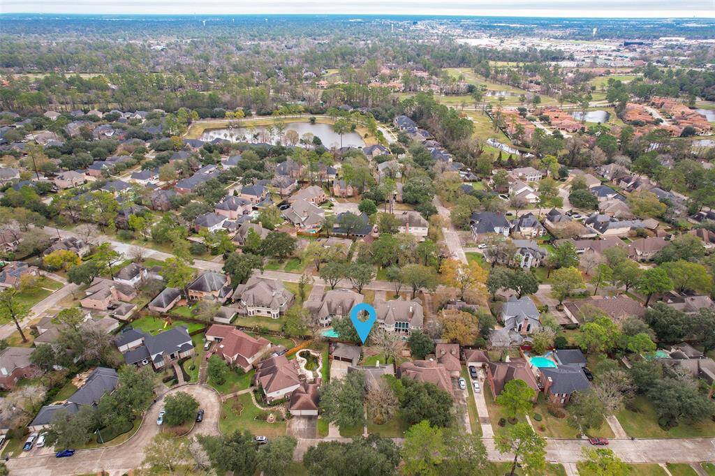 The aerial view shows the long and wide driveway leading to the 3-car garage, making this home ideal for families with multiple cars