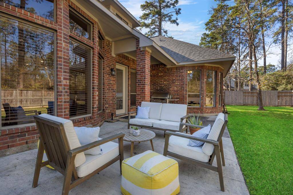 Unwind  on this charming extended patio with lush green views and cozy seating.