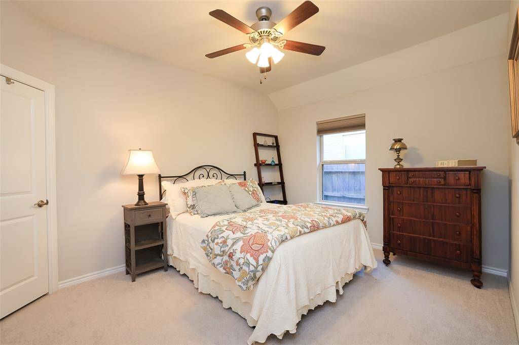 Secondary bedroom with carpet and spacious closet-split plan placement