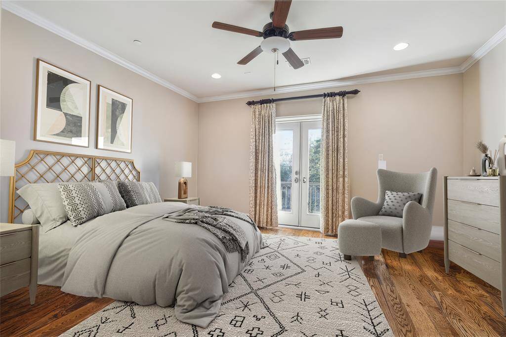 This inviting bedroom features hardwood floors, a cozy seating area, and French doors that open to a serene view.  (virtually staged)