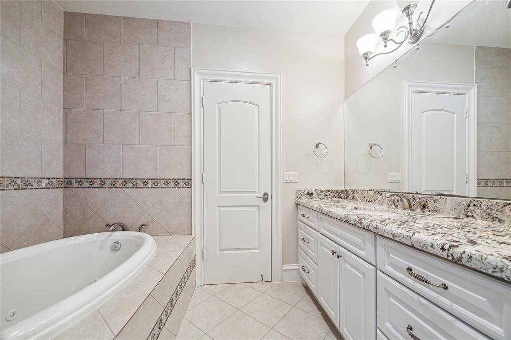 Another view of this bathroom features a soaking tub and tasteful tile accents.