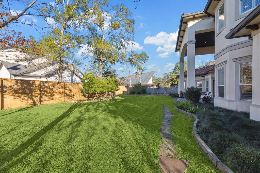 Spacious backyard with lush greenery, perfect for outdoor gatherings and relaxation. Enjoy privacy with a fenced perimeter and charming landscaping.