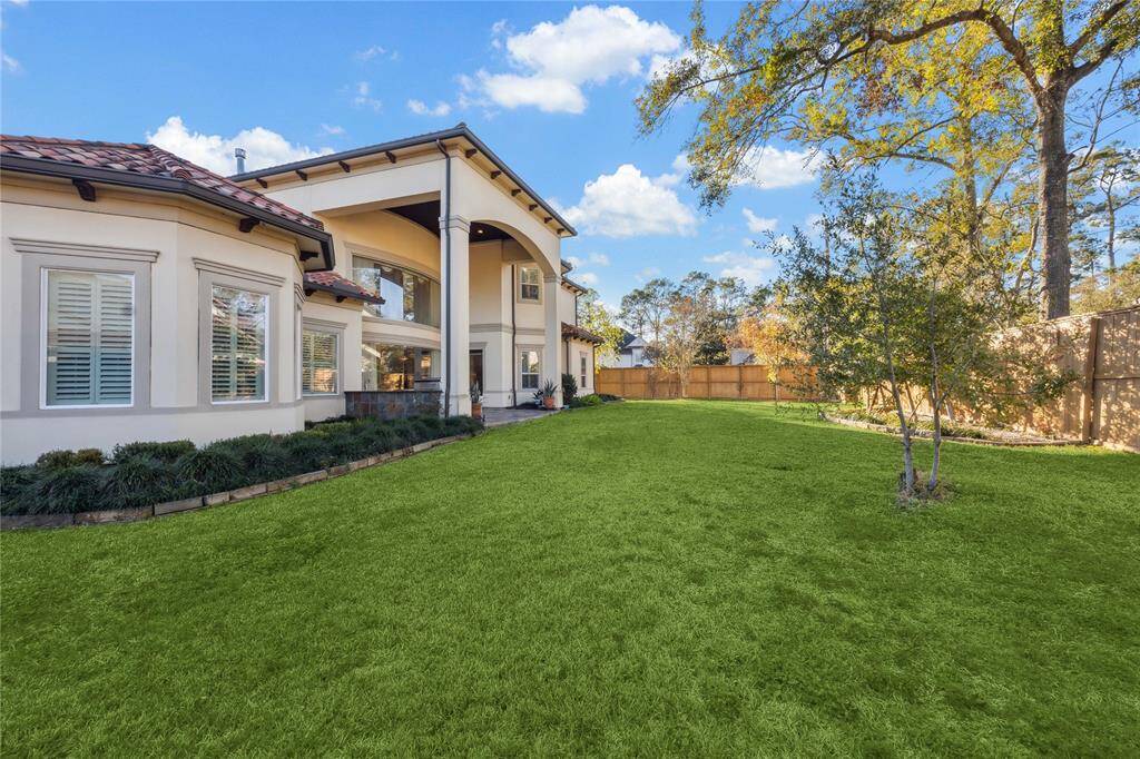 Elegant two-story home with expansive windows overlooking a lush, private backyard.