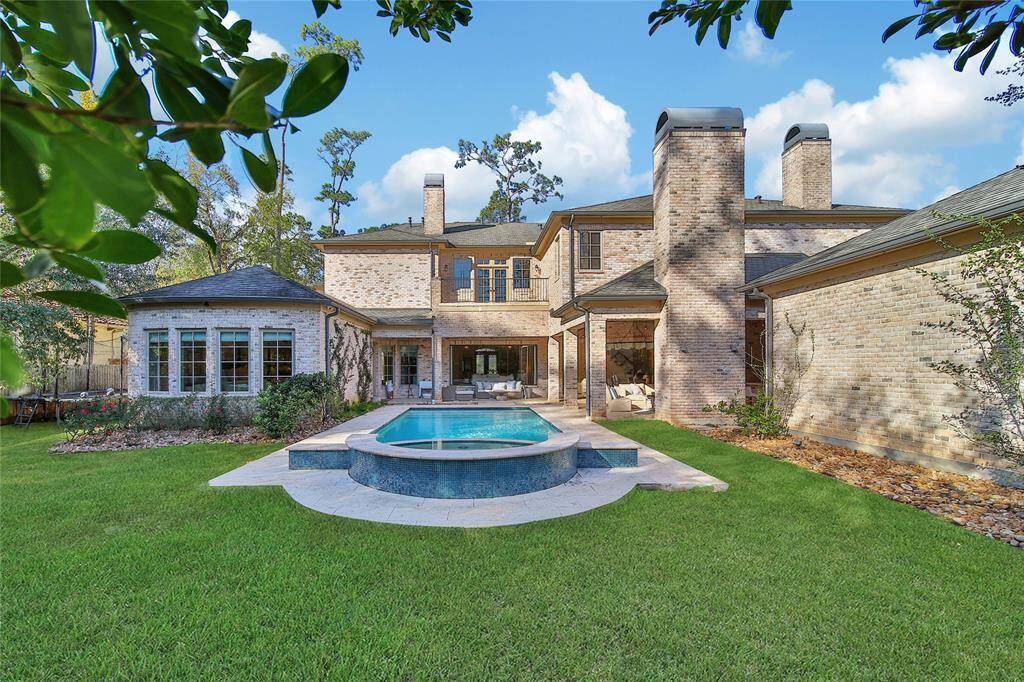 Stunning backyard featuring a pool and spa, a covered patio, and a fully-equipped outdoor kitchen.