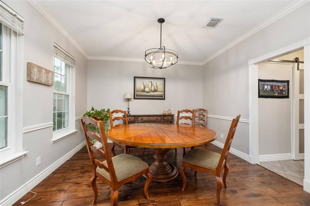 The Formal Dining Room has railing and crown molding details, along with wood flooring and enough space to accommodate your holiday or dinner guests.