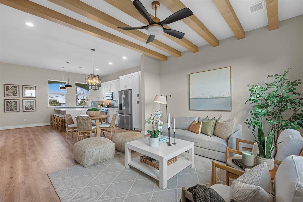 Take in this alternate view of the spacious living area, showcasing its perfect connectivity to the kitchen and dining area. The open layout ensures effortless flow, making it ideal for both intimate gatherings and larger entertainment.
