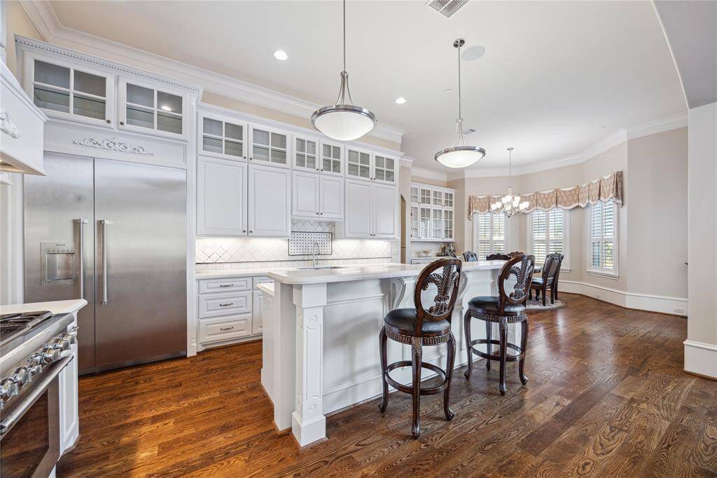 The kitchen features modern appliances, a spacious island with seating, and abundant natural light. Perfect for entertaining and everyday convenience.