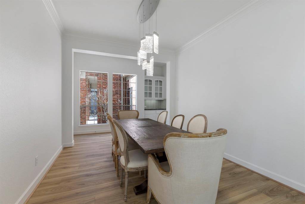 Large formal dining area with natural light and stylish wooden flooring—a perfect setting for gatherings.