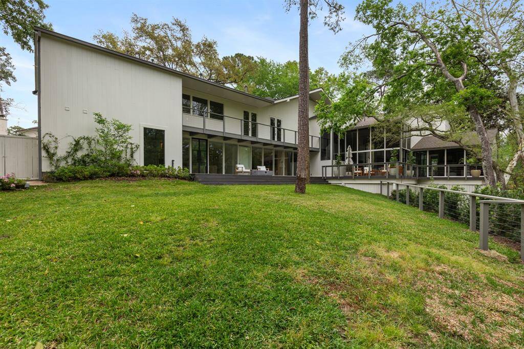 Welcome to your serene wooded backyard oasis in the heart of Houston! Surrounded by lush trees, this pool-sized yard offers endless possibilities for outdoor enjoyment. The expansive deck lines the entire back of the house, providing multiple access points from the study, formal living room, family room, and primary bedroom, making it perfect for entertaining and relaxation.