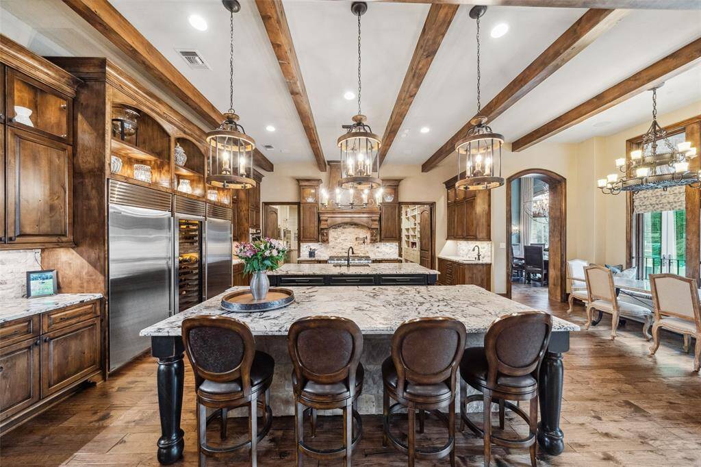 The chef's kitchen boasts two sinks with disposals, pot filler faucet, Thermador 6-burner gas range with griddle and two ovens, Thermador convection/steam oven and Thermador warming drawer and Sub-Zero refrigeration system including Sub-Zero Fridge, Freezer and Wine Chiller.