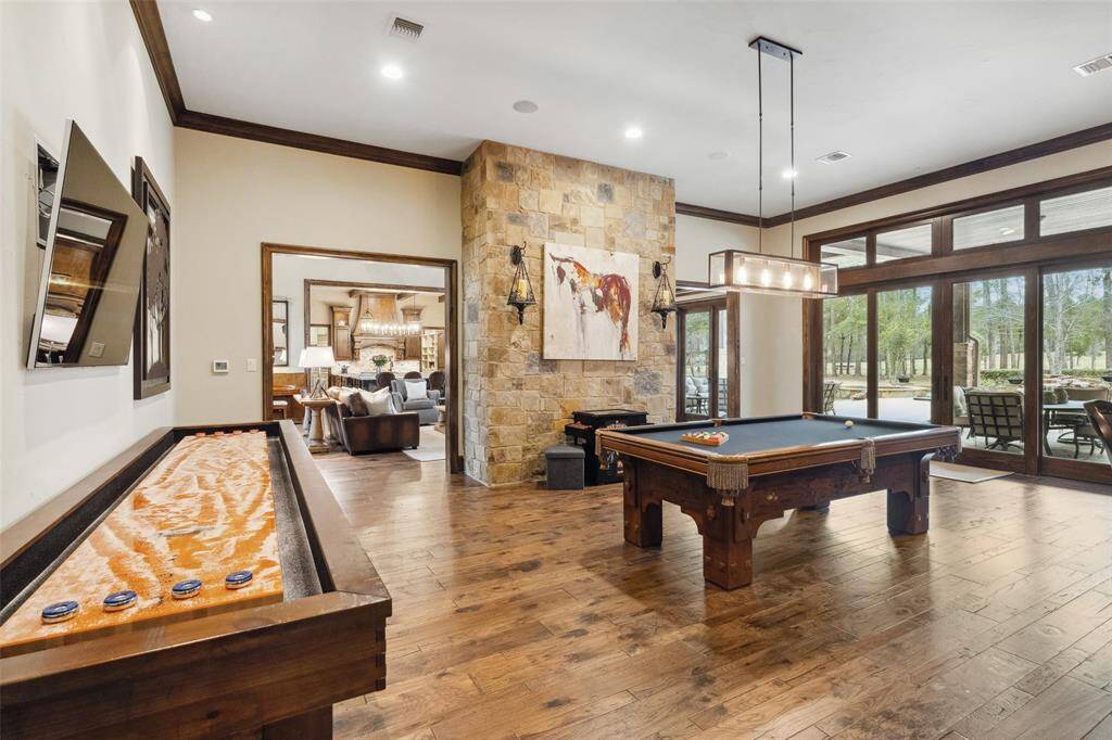 This open floorplan is perfect for entertaining family and friends or hosting a formal event. The game room is located on the opposite side of the living room fireplace, making it easy to utilize without isolating from the group! Flow effortlessly between the living room and culinary space to the game and media rooms and through the many French doors leading to the pool and outside entertainment areas.
