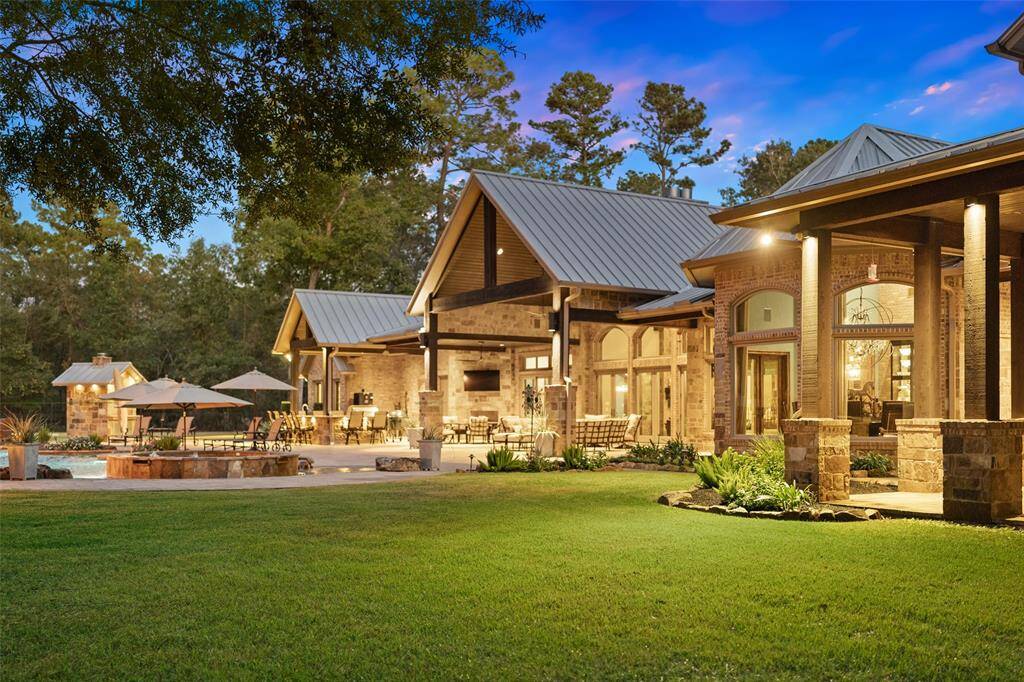 The stone and brick exterior elevation glows under the Texas sky. The home features a 60 year metal seam roof in silver and is fully guttered with gutter guards for easy maintenance. The gutters are plumbed directly to the pond for conservation efforts and wonderful drainage.  No stone has been left unturned.
