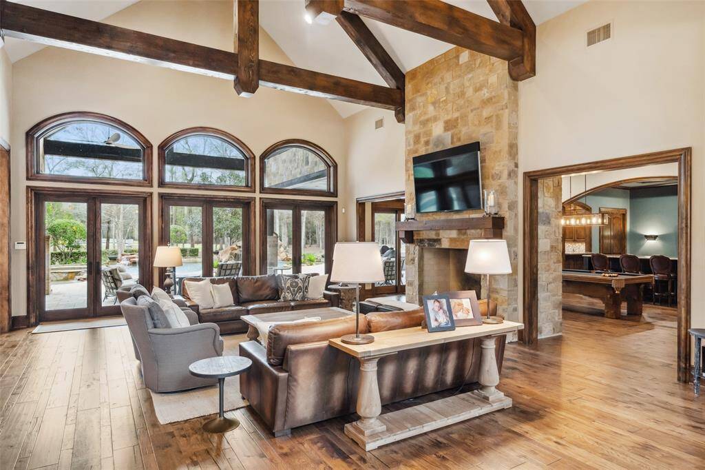 Just beyond the front entry, the generously sized family room serves as the heart of the home. The glass French doors and transoms afford stunning views of the property and provide effortless access to the covered veranda, sparkling pool and summer kitchen.