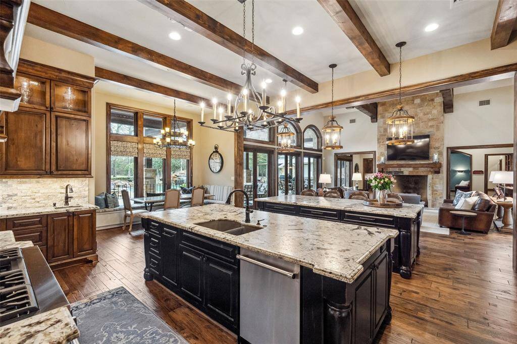 Open to the living room, the expansive gourmet kitchen features dual islands and is outfitted with exquisite custom cabinetry in contrasting finishes. Abundant drawers provide modern convenience for heavy pans and plentiful storage space.