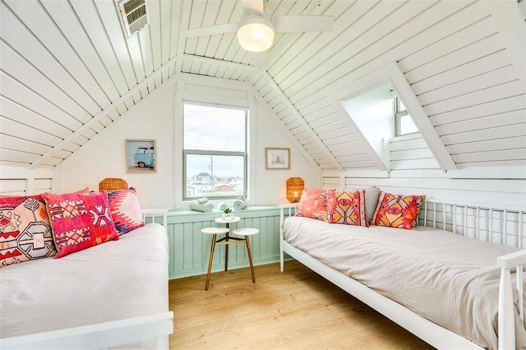 Cozy and bright bunk room with charming decor and ample natural light, perfect for relaxation.
