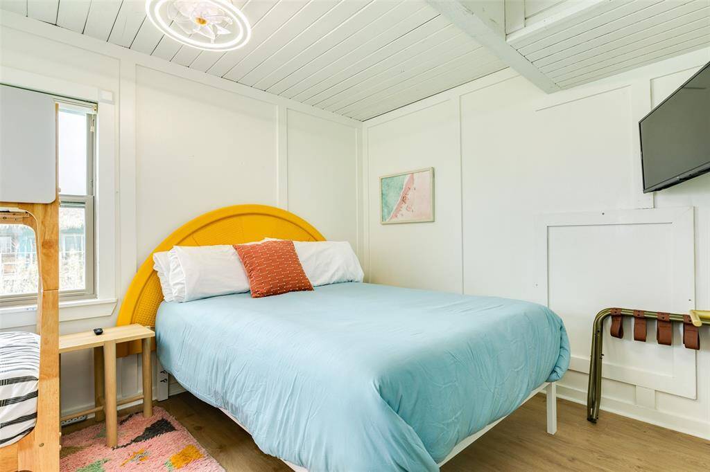 Bright bedroom featuring modern decor, a comfortable bed, and ample natural light. Perfect for relaxation.