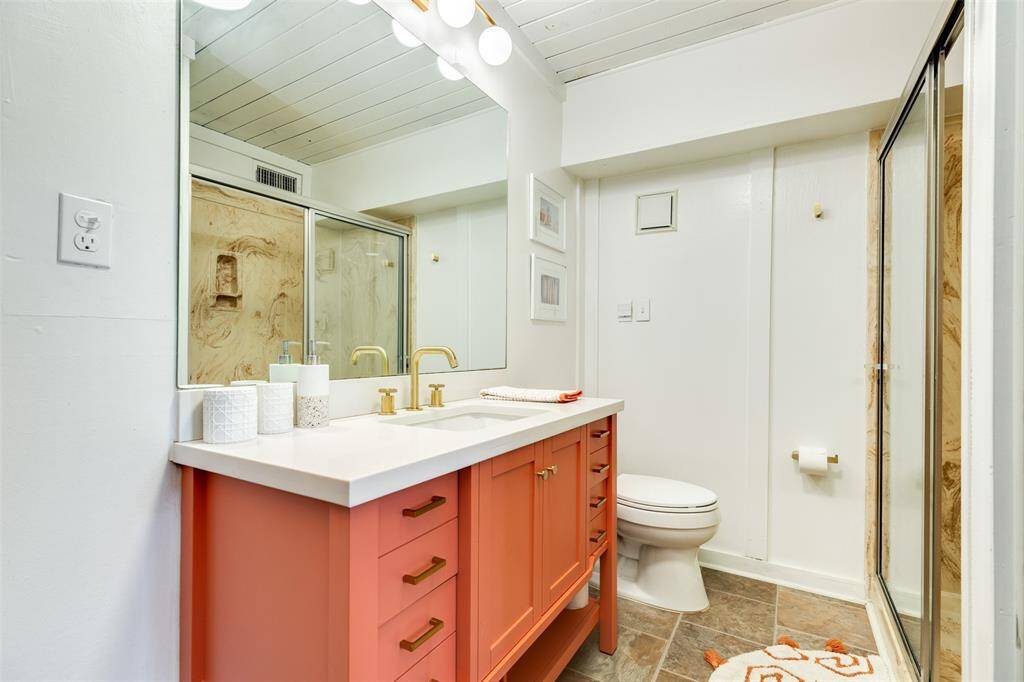 Modern bathroom featuring a stylish vanity, elegant fixtures, and a spacious shower, perfect for relaxation and rejuvenation.