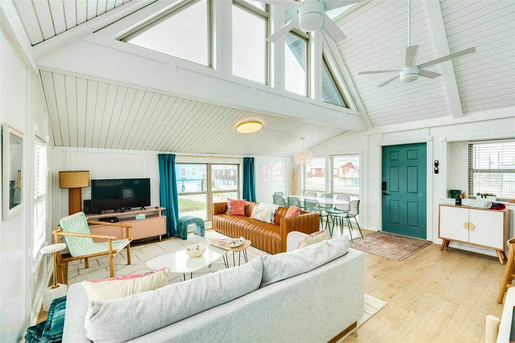 Flooded with natural light, this inviting living space features high ceilings and expansive windows, creating a bright and airy atmosphere.