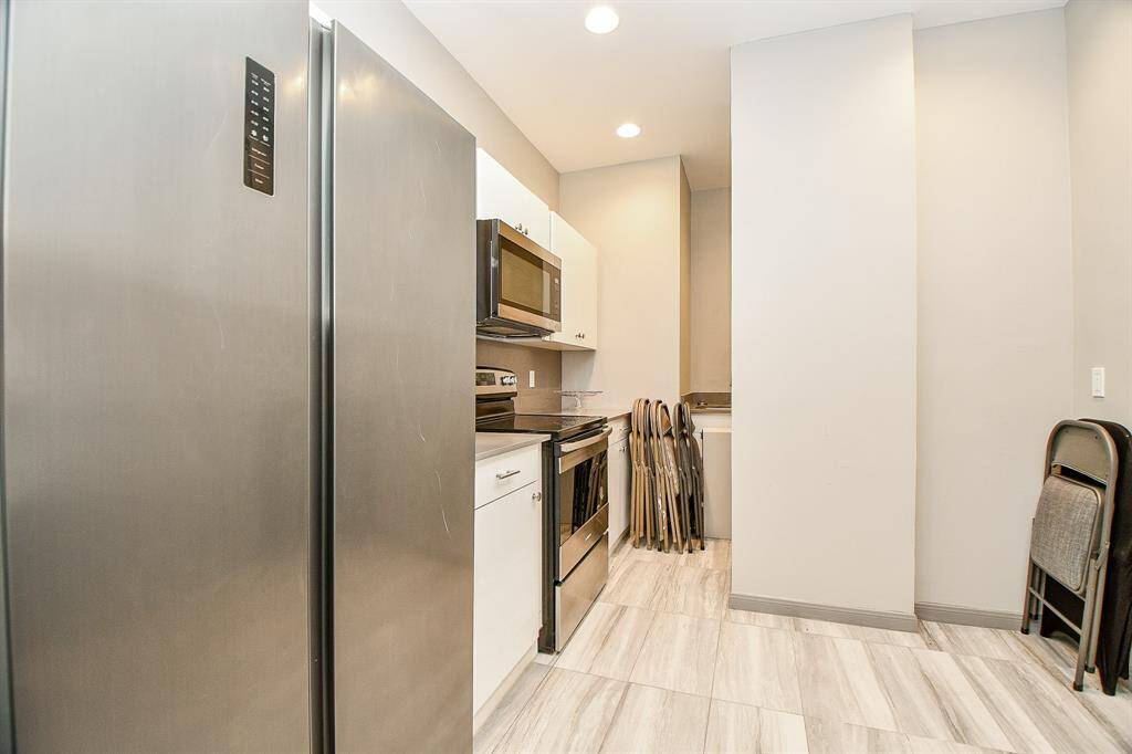 Catering kitchen off community room has refrigerator, stove, sink & dishwasher