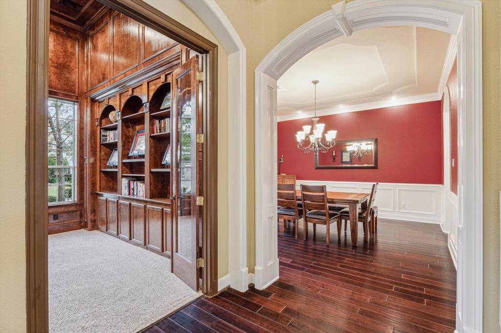 View of the home office and formal dining room with gleaming hardwood floors.