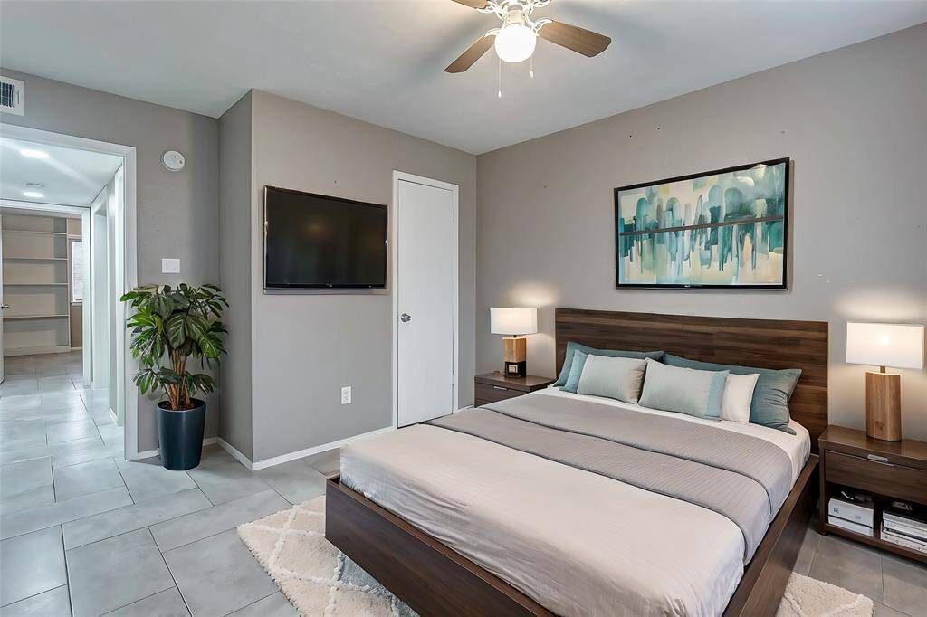 Another angle of the primary bedroom showcases its spacious layout and convenient access to the ensuite bathroom. The room’s open and modern design provides ample opportunity to create your ideal haven for relaxation.