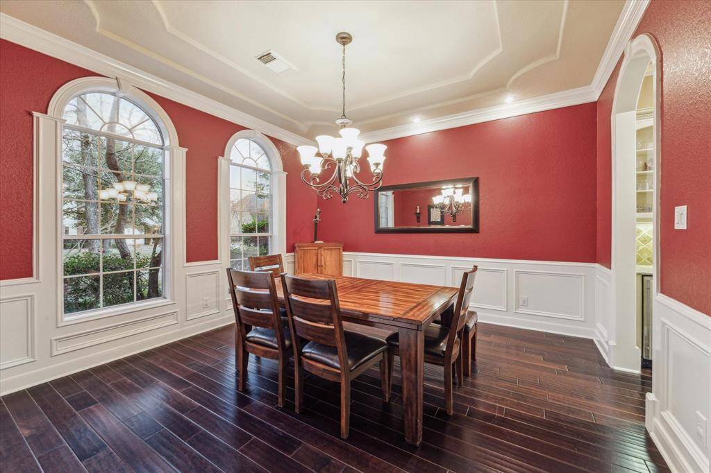Spacious formal dining room with crown molding and elegant millwork