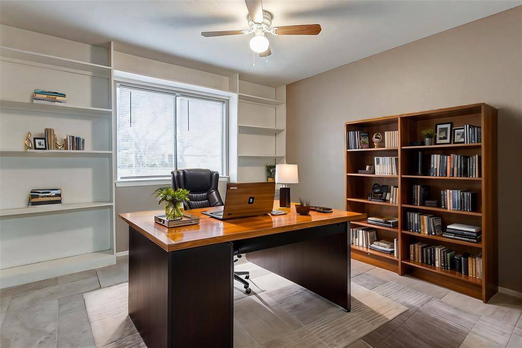 This versatile room features built-in shelving, ideal for showcasing books, collectibles, or décor. The neutral tones and updated tile flooring create a clean and modern feel. A large window floods the room with natural light, making it a perfect space for a home office, guest room, or creative studio.