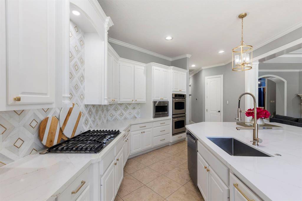 Prepare to be impressed by the ample countertop space, ideal for meal prep and entertaining. The kitchen is outfitted with a new range, a charming farmhouse-style sink, and tasteful gold accents, combining modern luxury with rustic appeal.