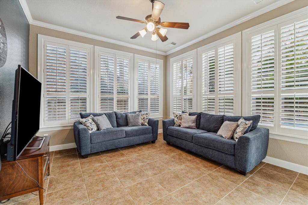 Sunroom area just off the kitchen with plantation shutters is a perfect flex space to fit your needs.