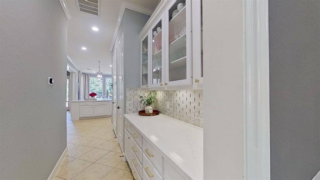 Updated Butler's Pantry with stylish glass-front cabinets, perfect for showcasing china or special items while offering practical storage.