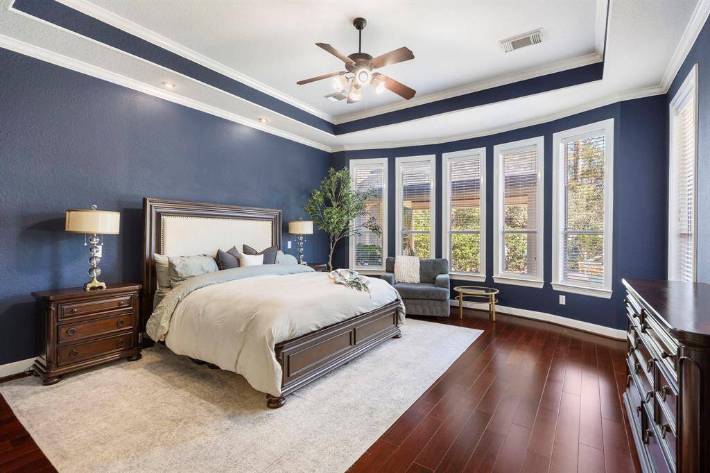 The handsome primary bedroom is generously sized, featuring elegant tray ceilings and an abundance of natural light that pours in, creating a bright and airy retreat. It’s the perfect space to unwind and relax after a long day.