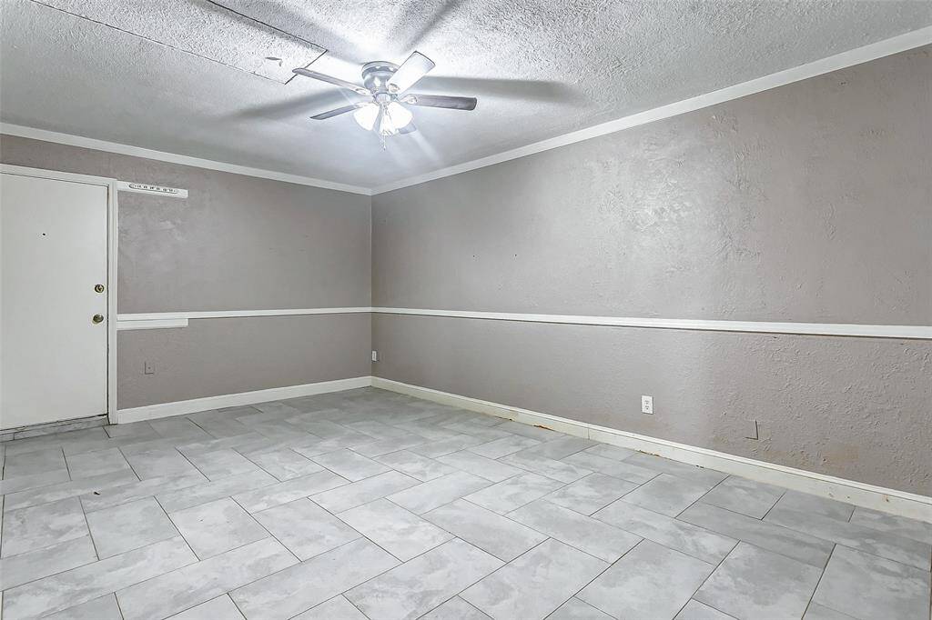 This generously sized bonus room is perfect for entertaining, a home gym, or a playroom. The clean design features fresh paint, elegant crown molding, and a ceiling fan for added comfort. A flexible area to suit your lifestyle needs, ready for customization.