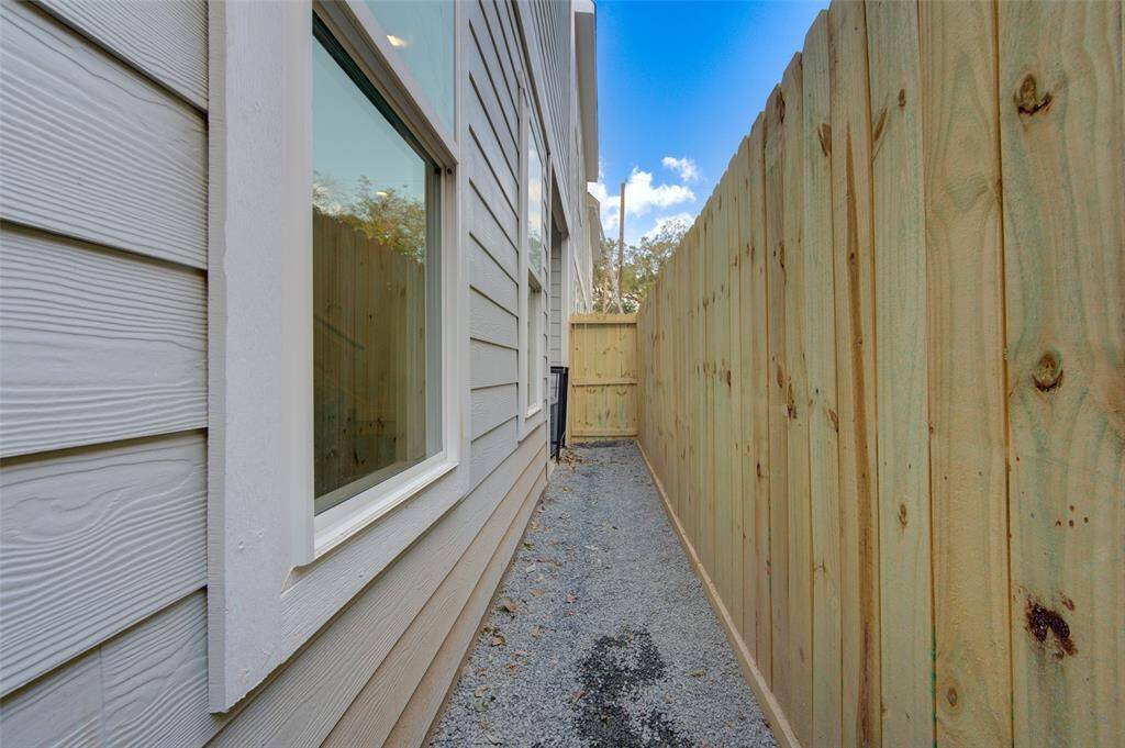 A private side yard with new fencing provides a secure and intimate outdoor space, perfect for a small garden or pet area. Enjoy peace and privacy with easy access from the home.