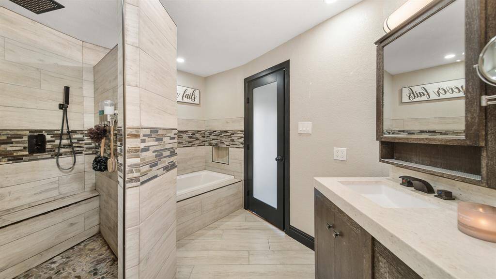 Primary Owner's Bath with Oversize Walk-In Shower with Complete Tile Surround, Separate Jetted Tub & Double Sinks.