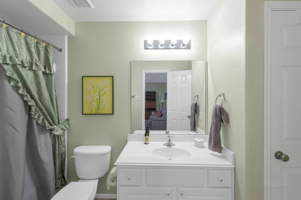 he spacious guest bathroom offers white countertops &cabinetry, and a tub/showercombination with a white tilesurround.