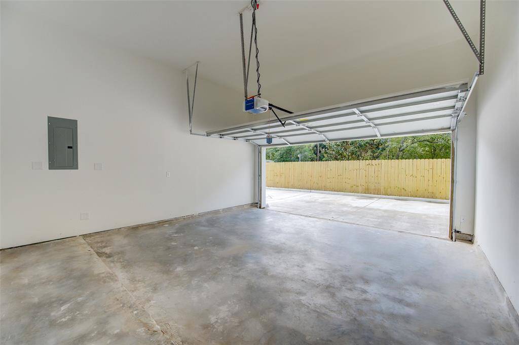 The attached two-car garage provides ample space for vehicles and storage. The clean, organized layout includes easy access to the backyard, enhancing convenience and functionality.