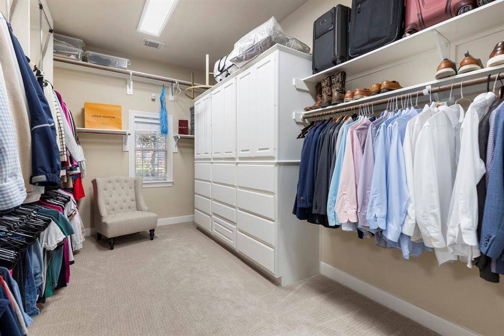 An amazing primary closet offering ample storage, built-in shelving, a pull-down upper closet system, and plenty of room to keep everything organized and easily accessible.