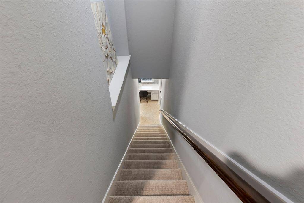 The secondary stairway features updated, high-end carpeting with a modern touch, offering both style and comfort as you move through the upstairs. Conveniently located off the kitchen and planning desk, it adds easy access and flow to the upper level.