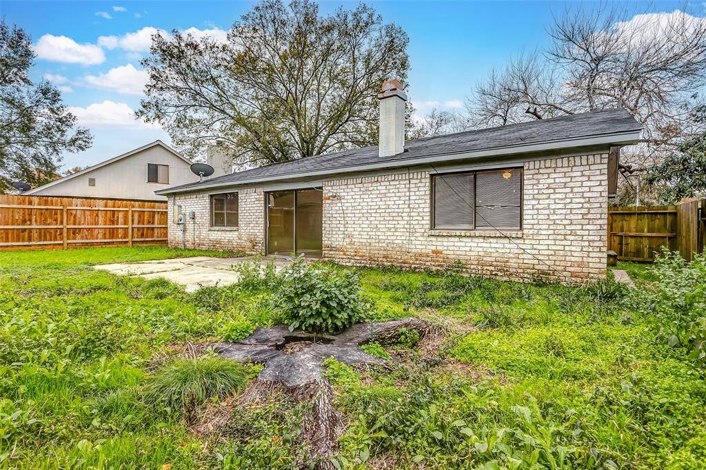 Another view of the backyard showcases its potential for customization. With mature trees and a fenced perimeter, this outdoor space offers a peaceful retreat to enjoy nature or create your ideal setup.