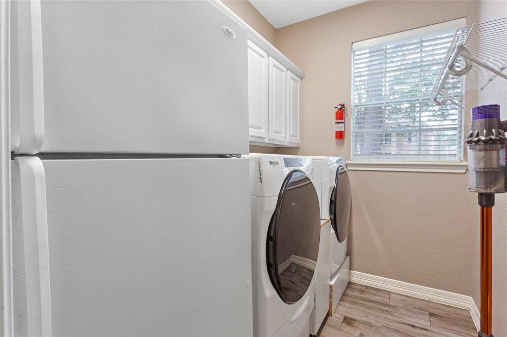 Oversized utility room with cabinets for storage and room for an additional full sized refrigerator, just off the kitchen.