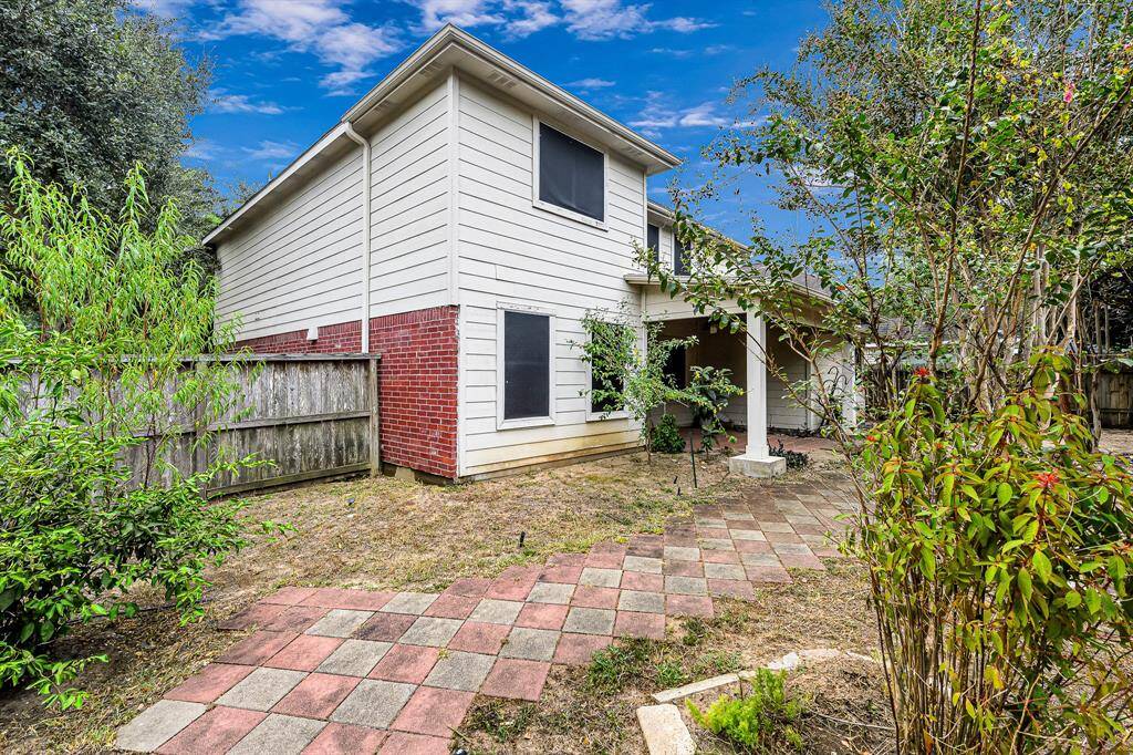 Take note of the checkered pattern of red and gray pavers that extends from the patio to the side of the house. You also have an abundance of mature shrubs and plants, providing a quiet and private atmosphere with a clear view of the sky above.