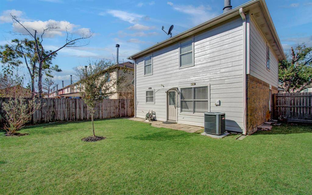 Another view of well-maintained backyard with a paved patio space.