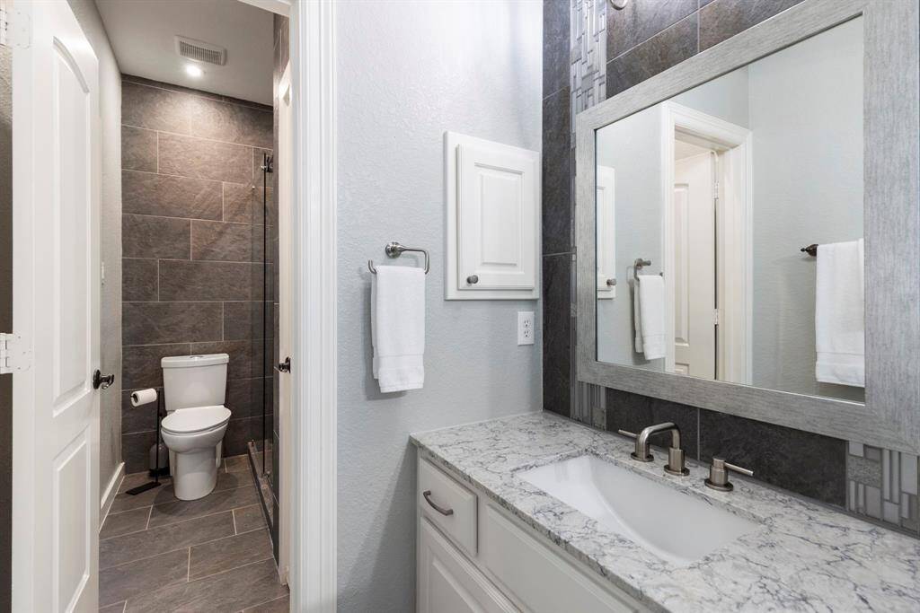 The Jack and Jill bathroom has been updated with Quartz countertops and stunning tilework in both the shower and vanity, offering a perfect blend of style and functionality.