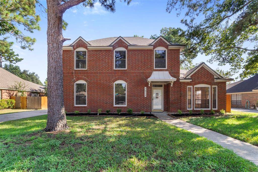 This charming two-story brick home features a classic facade with large windows and a welcoming front entrance. Surrounded by mature trees, it offers a spacious front yard and a paved driveway leading to a detached garage. Perfect for those seeking a blend of elegance and comfort.