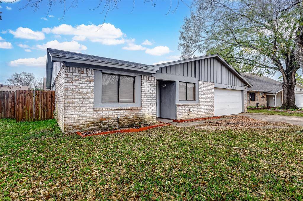 A closer perspective reveals the inviting entrance and front windows that allow for plenty of natural light. The charming gray tones of the exterior brick and trim perfectly contrast the lush green lawn. With ample yard space for gardening or relaxing, this home is ideal for those who value outdoor living. The modern appeal is matched by the peaceful surroundings of this serene neighborhood.