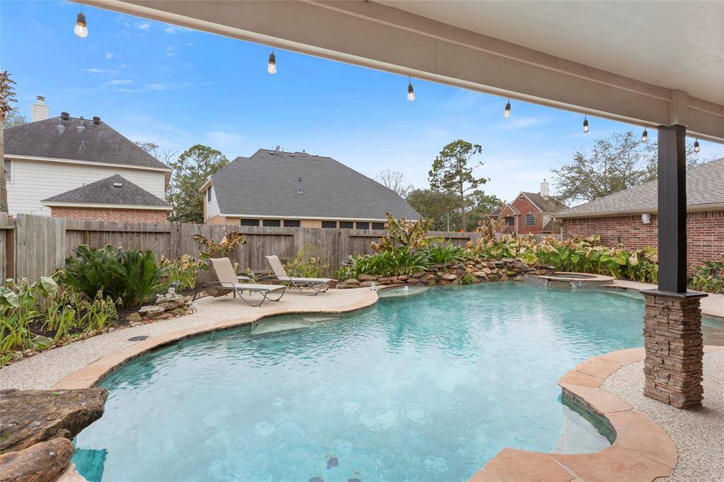 Lagoon style heated pool with diving rock, rock water feature, bubblers plus a raised spa with spillway.